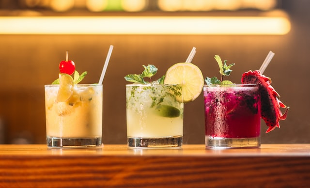 A row of soju cocktails in glasses, like a soju margarita and soju mojito.